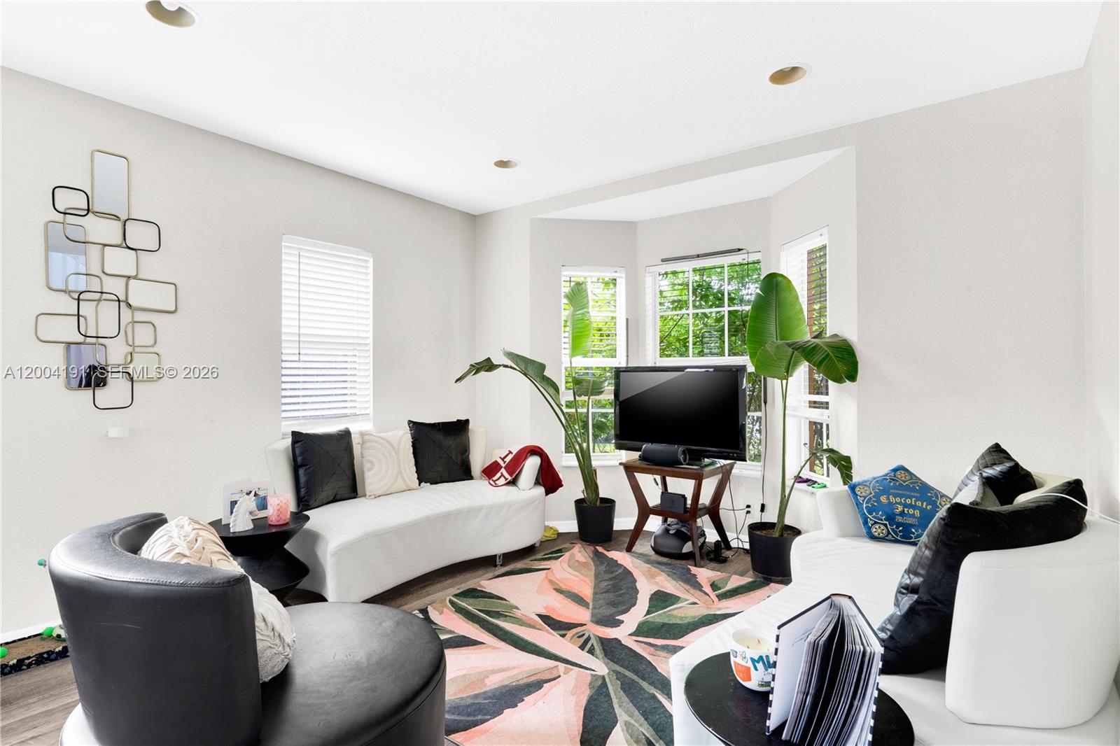 This living room features white sofas, a patterned area rug, and two large potted plants — 9031 SW 208th Ter, Cutler Bay FL 33189, CUTLER BAY, FL