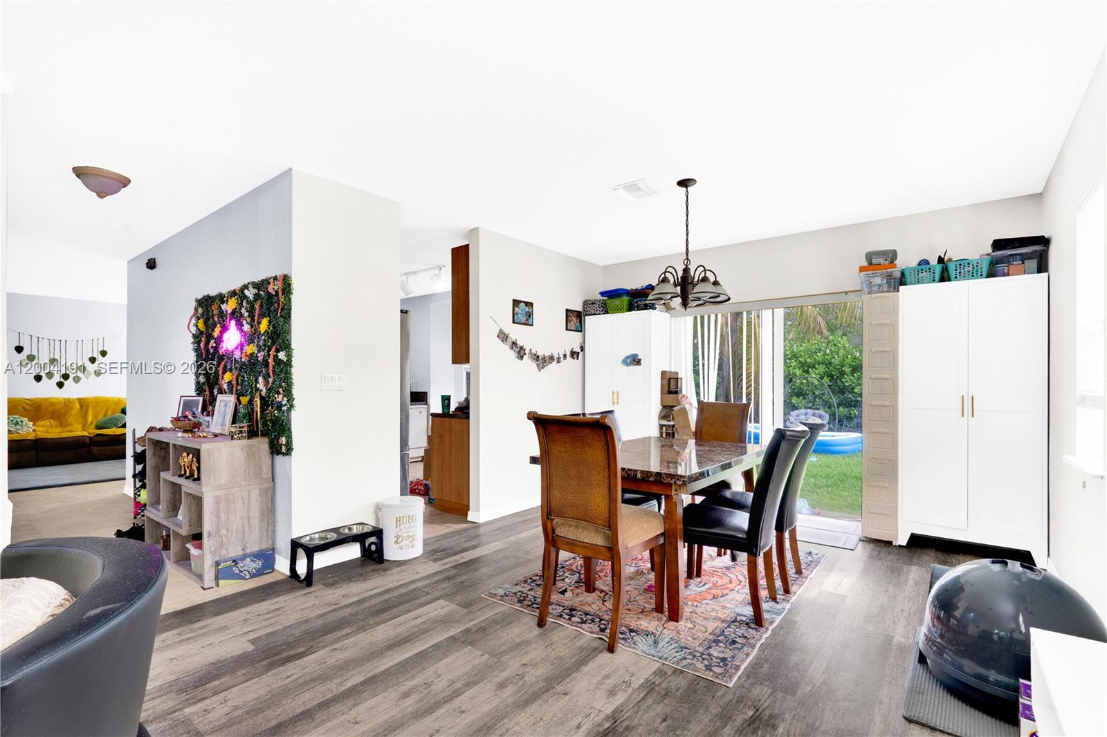 A dining area with a marble-topped table, dark chairs, and a sliding glass door — 9031 SW 208th Ter, Cutler Bay FL 33189, CUTLER BAY, FL