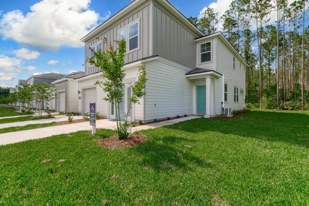 A two-story suburban house with white horizontal siding and a teal front door — 10721 WATERFIELD ROAD, JACKSONVILLE, FL
