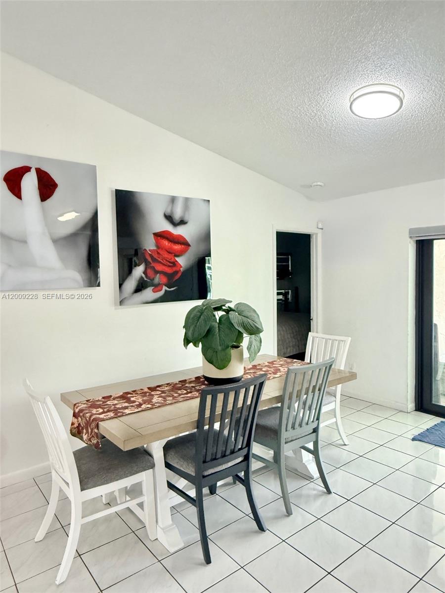 A dining room features a wooden table with four chairs, a plant, and wall art — 11216 SW 166th Ter, Miami FL 33157, MIAMI, FL