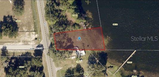 This aerial map shows a waterfront property lot outlined in red next to a road — CR-33, GROVELAND, FL
