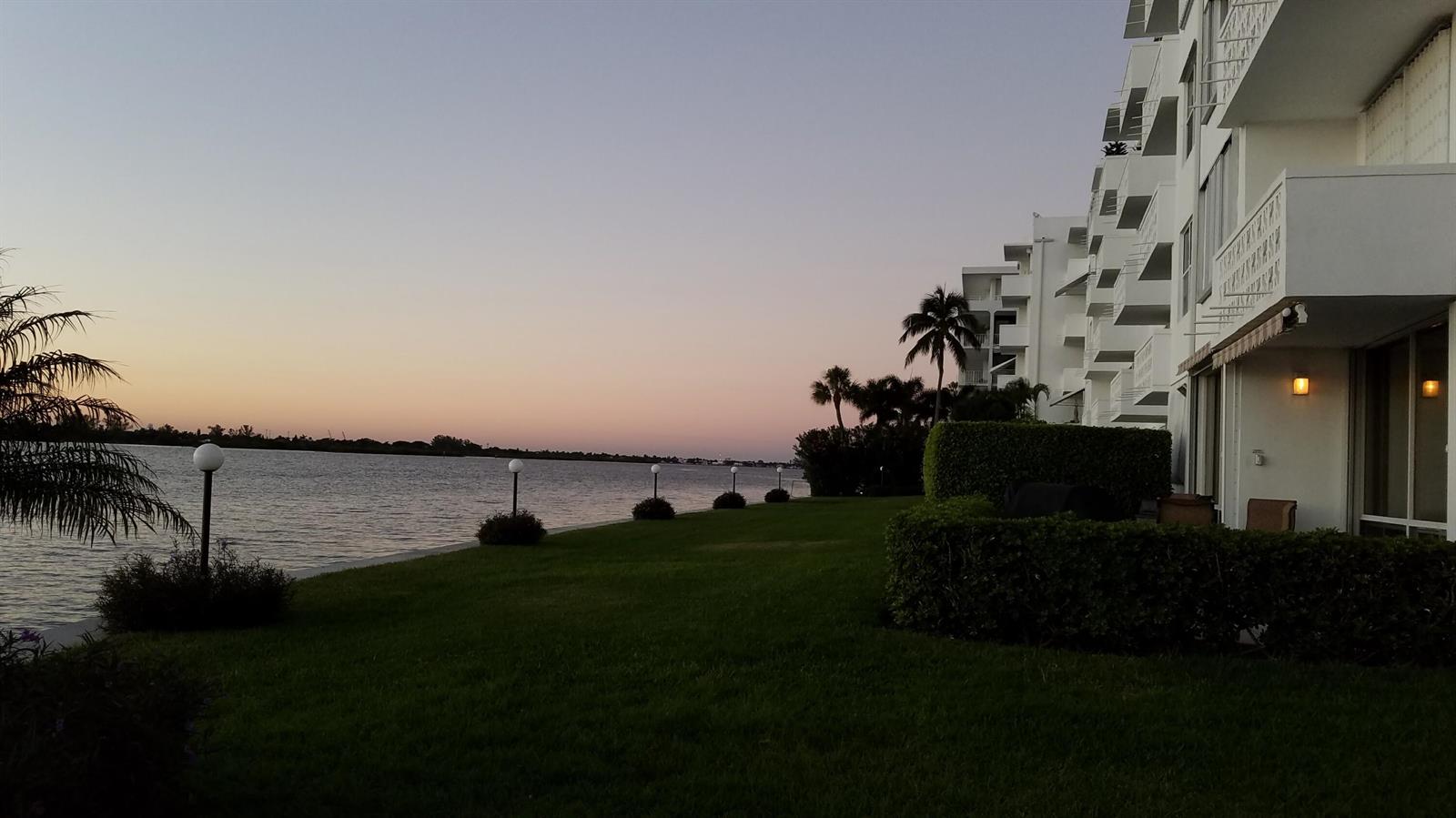 A white multi-story apartment building sits beside a grassy lawn overlooking a calm body of water — 2840 S Ocean Boulevard # 3230, Palm Beach FL 33480, PALM BEACH, FL