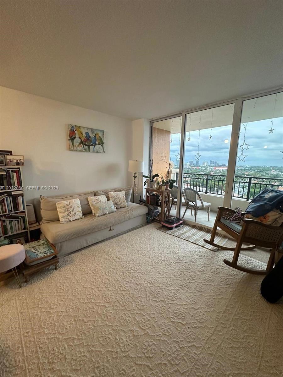 A living room features a beige sofa, a rocking chair, and a balcony with views — 3232 SW 22nd Ter # 1607, Miami FL 33145, MIAMI, FL