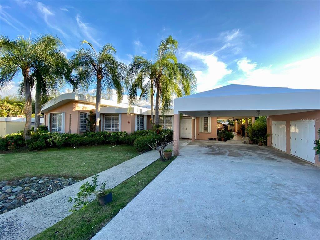 A single-story house with a large carport, palm trees, and a concrete driveway — 2 St. ESTANCIAS DEL LAGO UNIT D-4, CAGUAS, PR