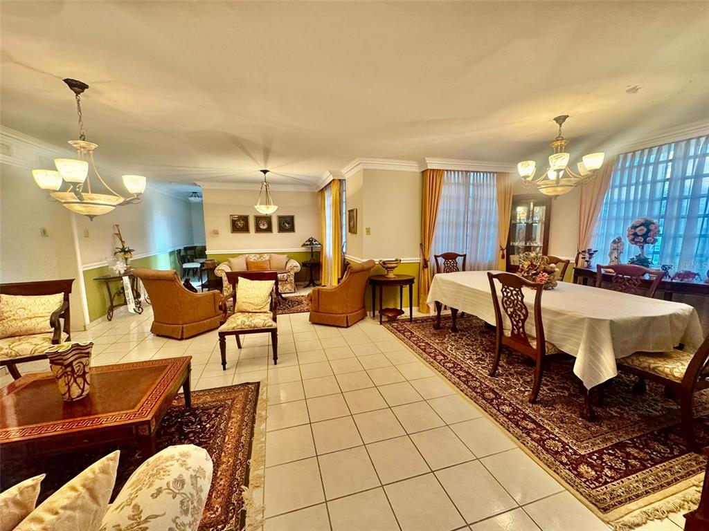 A spacious living and dining area features tile floors, area rugs, and two chandeliers — 2 St. ESTANCIAS DEL LAGO UNIT D-4, CAGUAS, PR