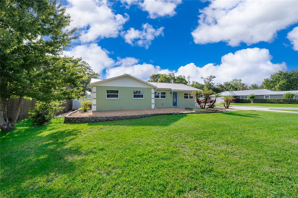 A single-story house with light green siding and a blue front door sits on a lawn — 437 OREGON AVENUE, ST CLOUD, FL