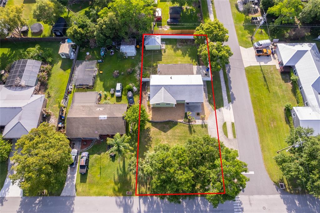 An aerial view shows a house with a metal roof and a fenced backyard — 437 OREGON AVENUE, ST CLOUD, FL