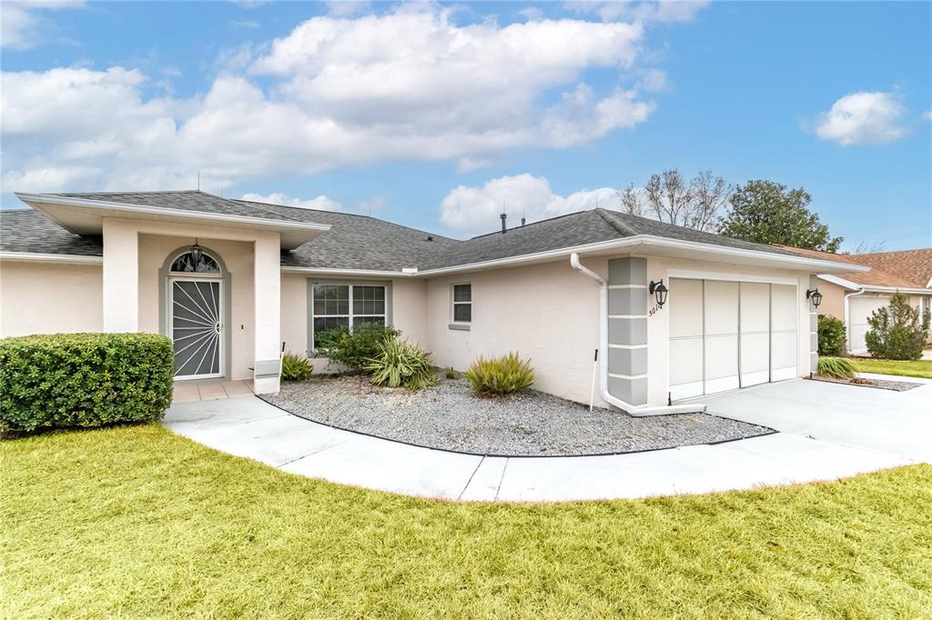 A single-story house with a light-colored exterior, a two-car garage, and a large front lawn — 5011 NW 31ST STREET, OCALA, FL