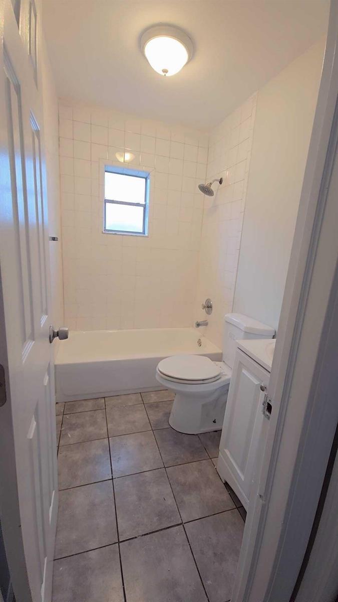 A small bathroom features a tiled shower-tub combination, a white toilet, and a vanity — 621 NW 5th Avenue Unit 3, Pompano Beach FL 33060, POMPANO BEACH, FL