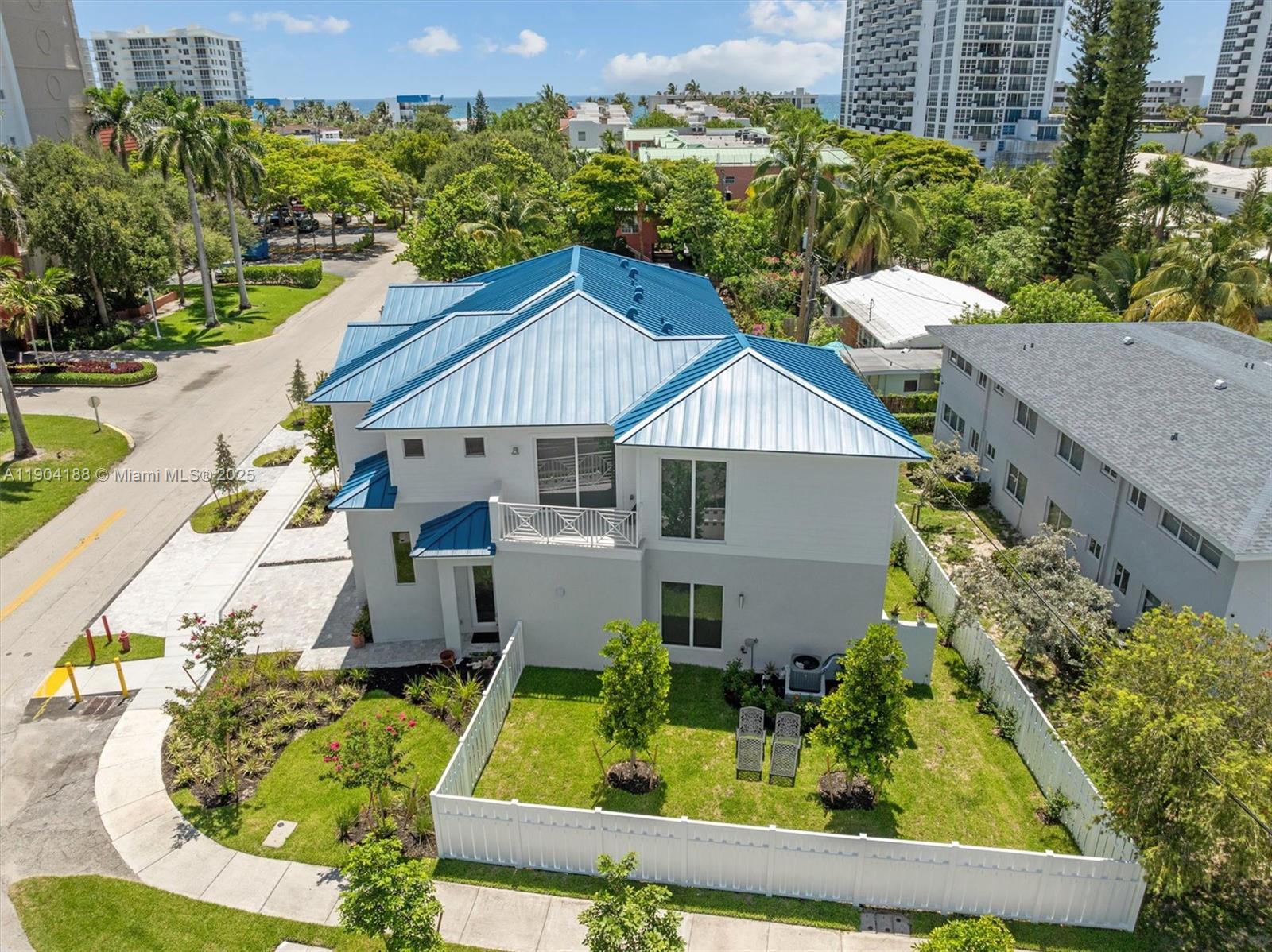 An aerial view shows a two-story house with a blue metal roof and fenced yard — 554 N Riverside Dr # B, Pompano Beach FL 33062, POMPANO BEACH, FL