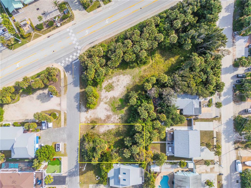 An aerial view shows a vacant, rectangular lot outlined in yellow surrounded by residential properties — 833 MARALYN AVENUE, NEW SMYRNA BEACH, FL