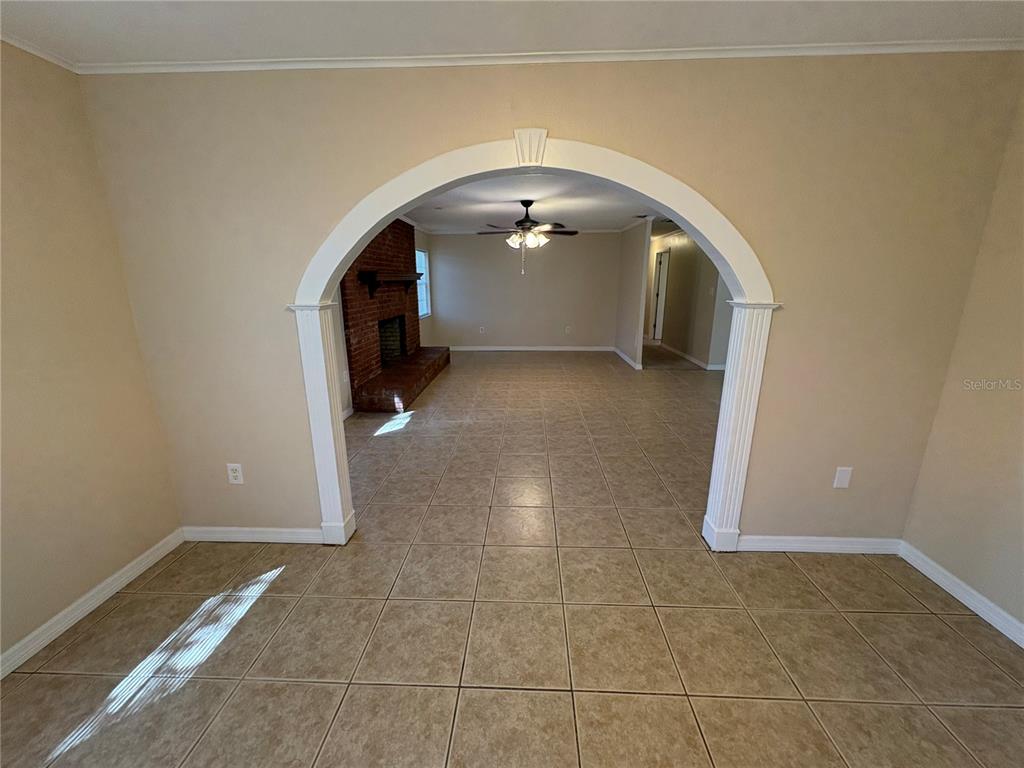 A tiled room features a large arched entryway leading to a living area with a fireplace — 8351 WAKEFORD ROAD, LAKE WALES, FL