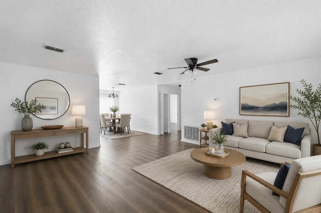 A bright living room and dining area feature white walls, wood flooring, and neutral furniture — 47 WATER TRACK LOOP, OCALA, FL
