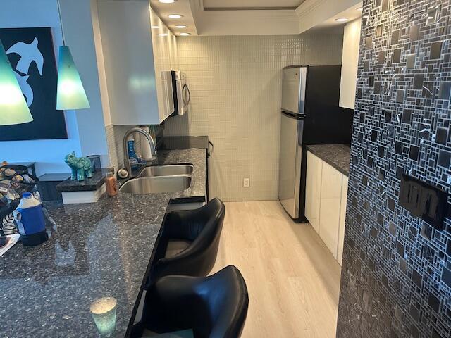 A kitchen features dark granite countertops, stainless steel appliances, and a mosaic tile accent wall — 531 N Ocean Boulevard # 903, Pompano Beach FL 33062, POMPANO BEACH, FL