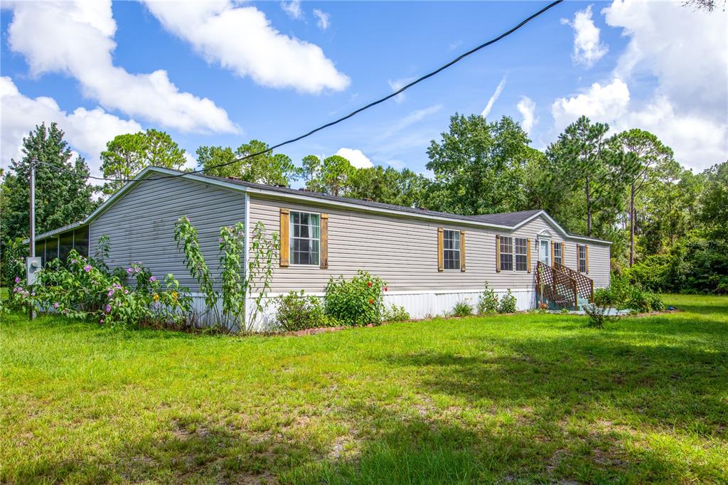 A single-story manufactured home with light gray siding sits on a grassy lot — 104 EVERETT STREET, PALATKA, FL