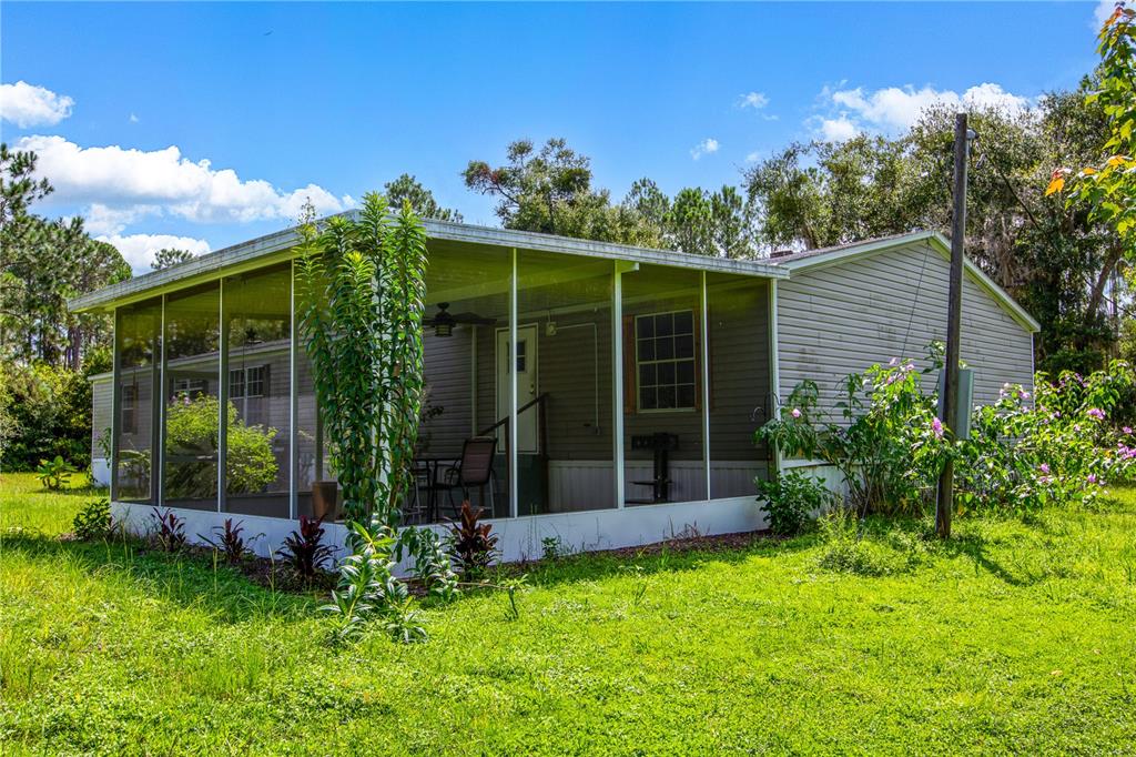 A single-story house with light gray siding and a large, screened-in front porch — 104 EVERETT STREET, PALATKA, FL