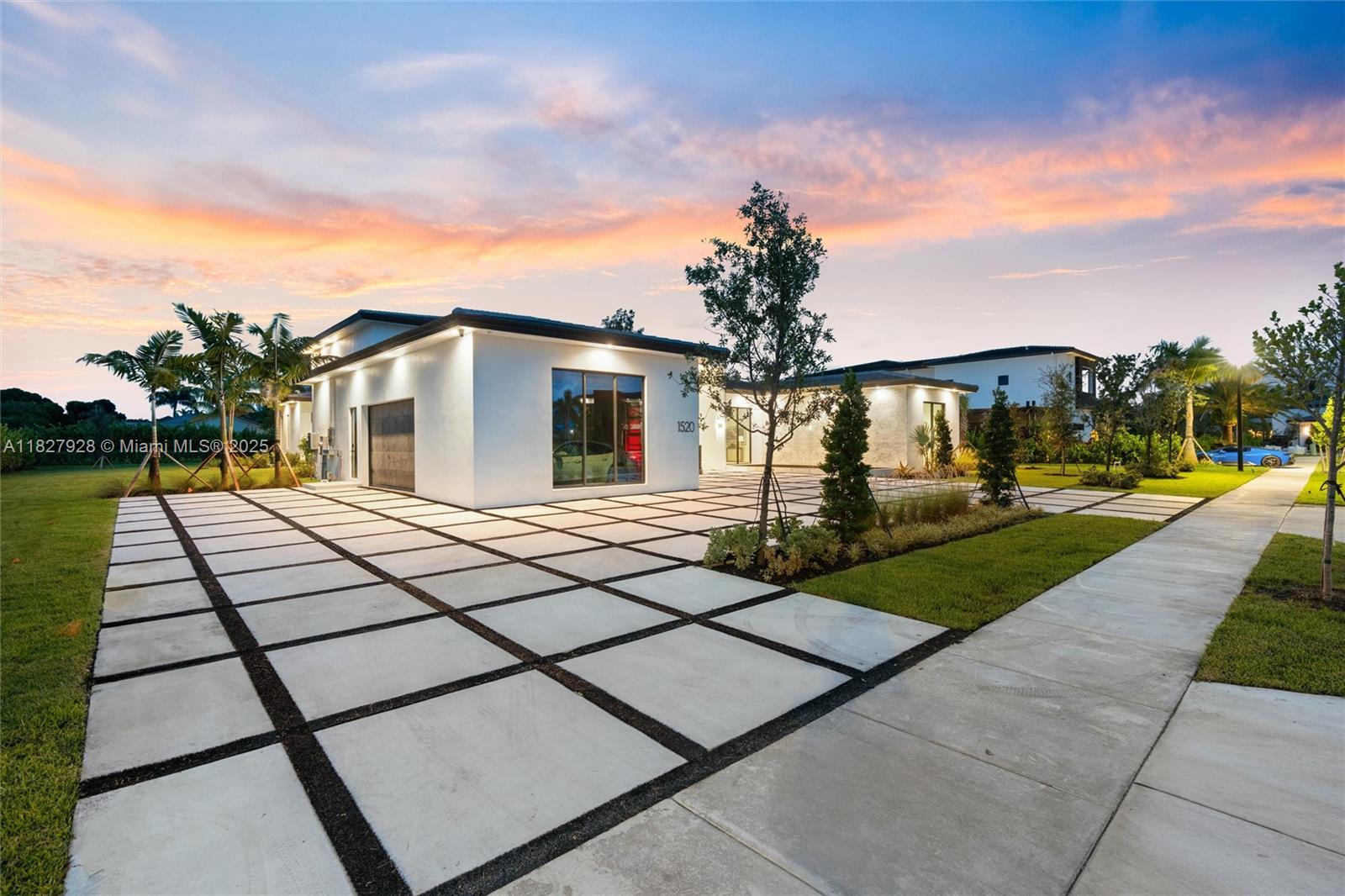 A modern white house with a large grid-patterned concrete driveway at sunset — 1520 SW 149th Ter, Davie FL 33326, DAVIE, FL
