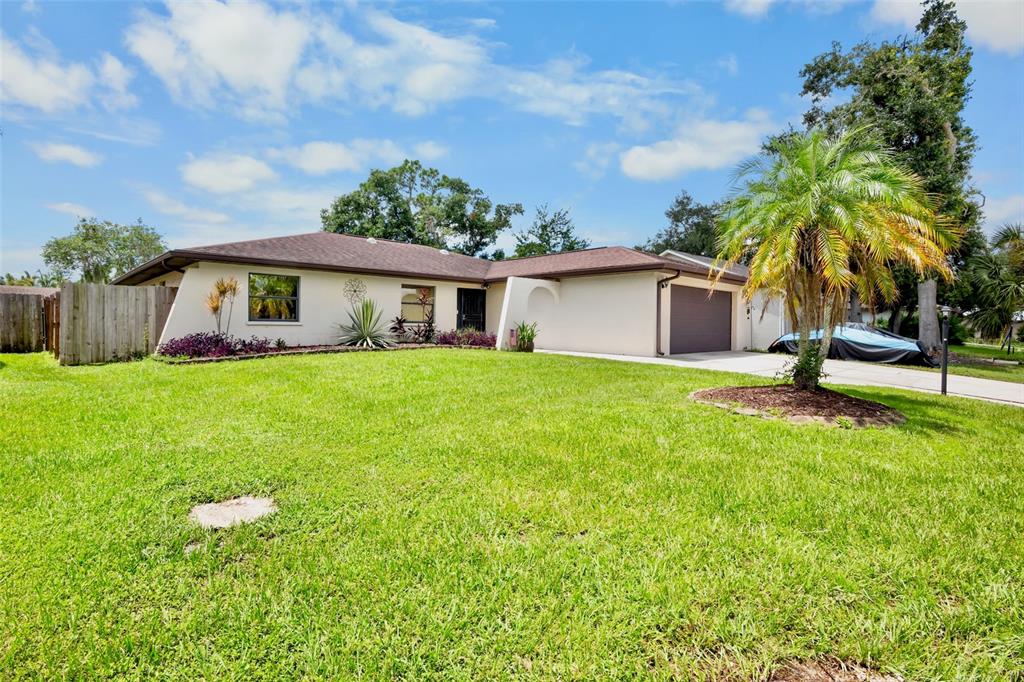 A single-story house with a brown roof, beige exterior, and a front-facing garage — 6816 MAUNA LOA BOULEVARD, SARASOTA, FL