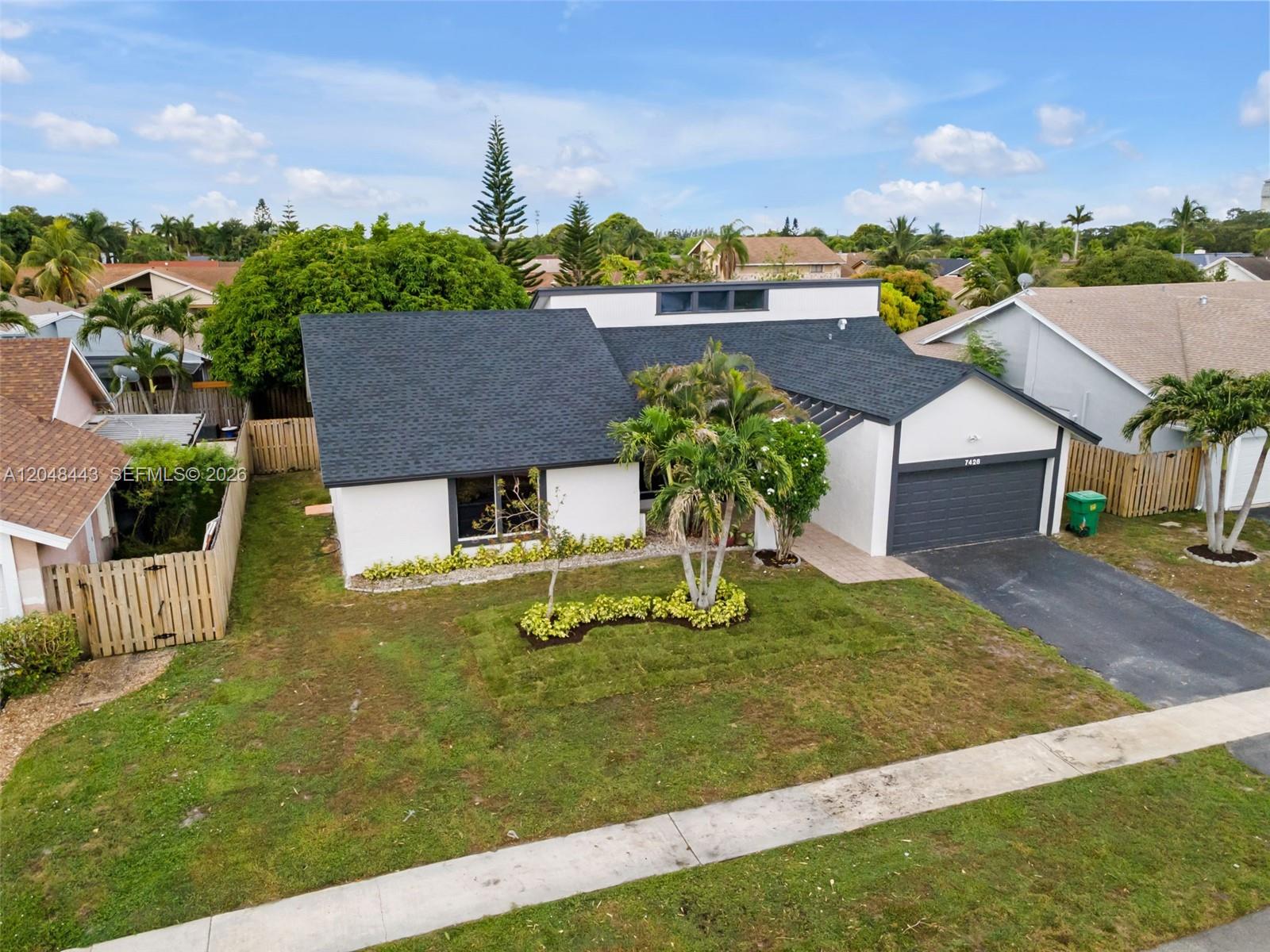 An aerial view shows a single-story house with a dark roof and white exterior walls — 7428 NW 49th Ct, Lauderhill FL 33319, LAUDERHILL, FL