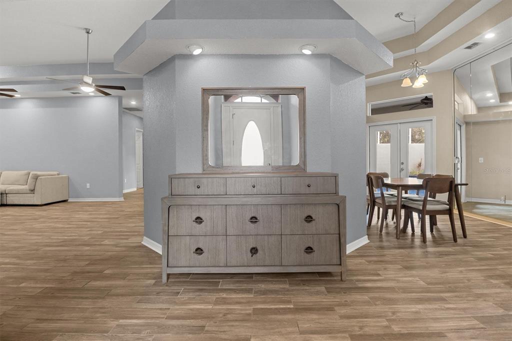 A gray dresser with a mirror sits against a central wall in an open-concept room — 5446 HIGHLANDS VISTA CIRCLE, LAKELAND, FL