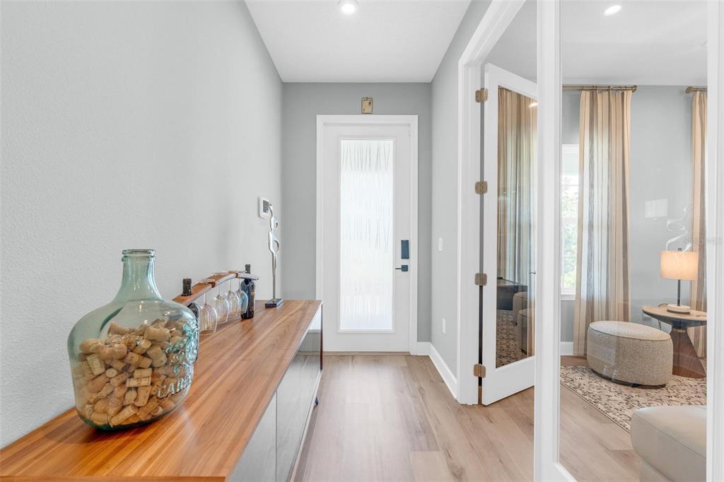 A hallway features light wood flooring, a wooden console table, and a glass-paneled entry door — 3009 ROBLES ROAD, CLERMONT, FL