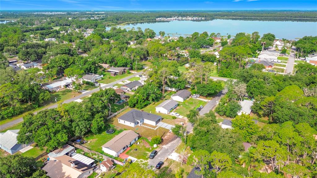 An aerial view shows a suburban neighborhood with houses, trees, and a large lake nearby — 6446 FALL STREET, ST CLOUD, FL
