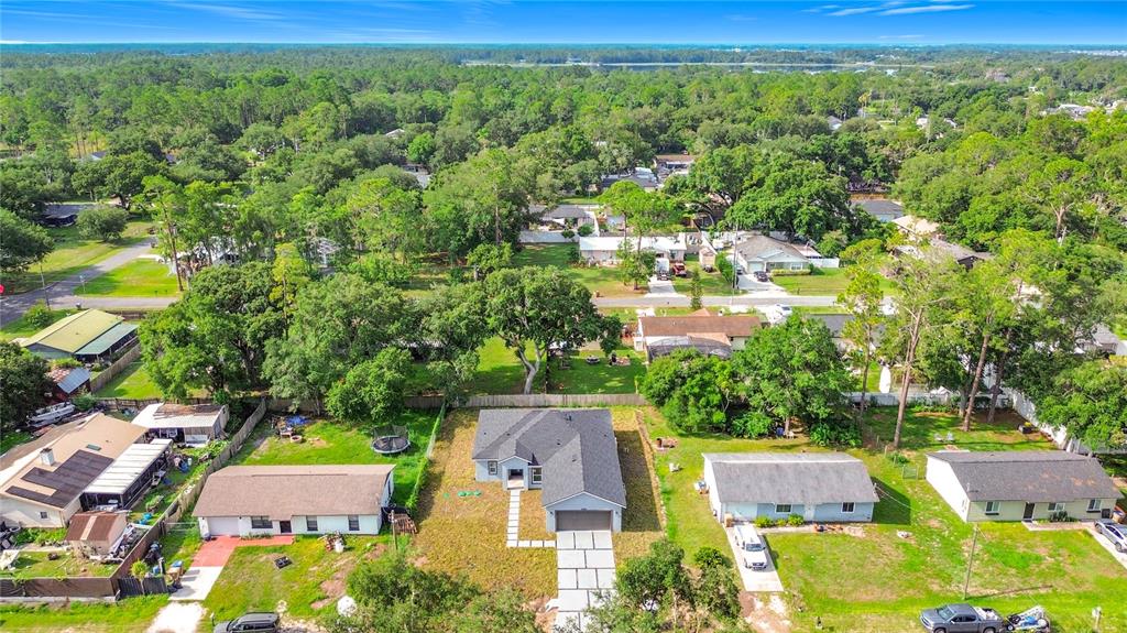 An aerial view shows a single-story house with a gray roof and a concrete driveway — 6446 FALL STREET, ST CLOUD, FL