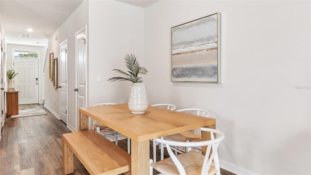 A dining area features a wooden table with a bench and white chairs — 4131 MILLER POINTE COURT, BRADENTON, FL