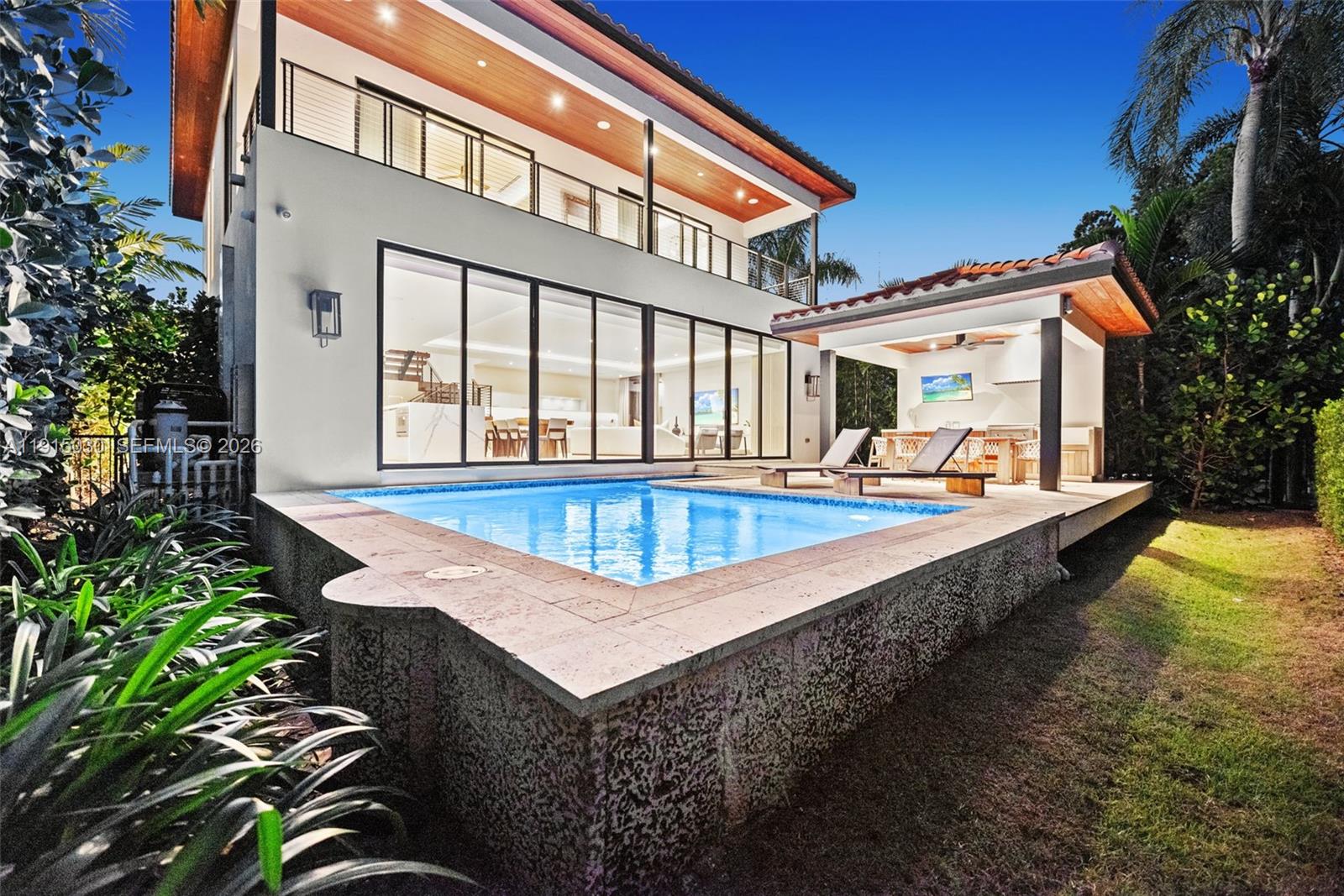 A modern two-story house features a swimming pool, a covered patio, and large glass doors — 5831 Alton Rd, Miami Beach FL 33140, MIAMI BEACH, FL