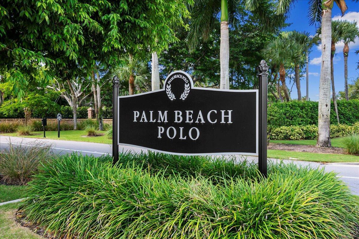 A black sign reading Palm Beach Polo stands in a landscaped area with palm trees — 11863 Wimbledon Circle # 441, Wellington FL 33414, WELLINGTON, FL