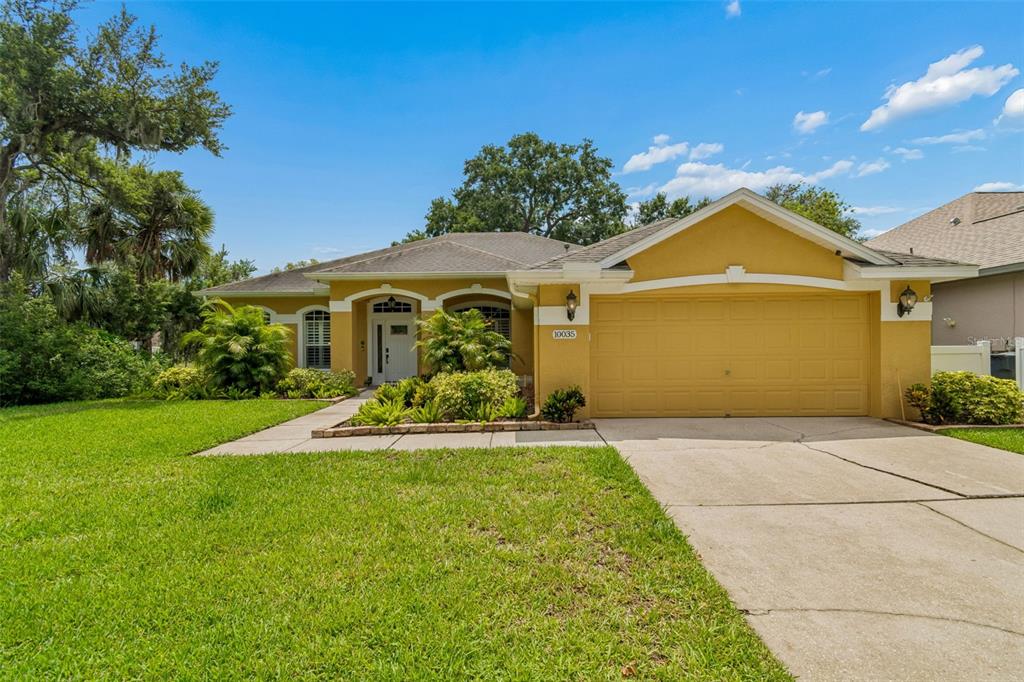 A yellow single-story house with a white front door and a concrete walkway — 10035 REMINGTON DRIVE, RIVERVIEW, FL