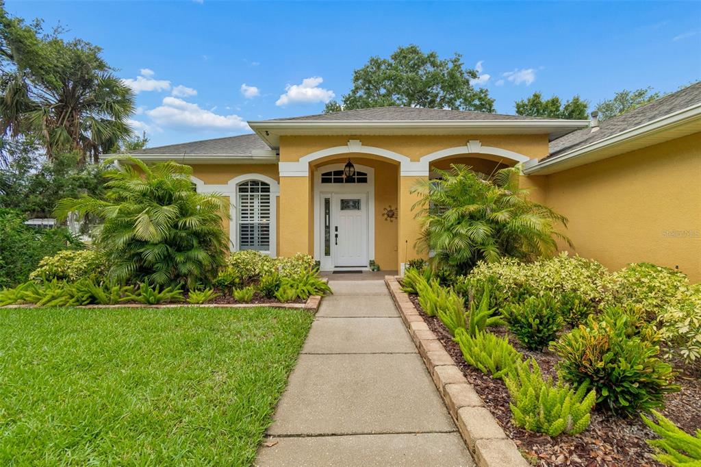 A screened-in patio with brick flooring, wicker furniture, and a view of a lake — 10035 REMINGTON DRIVE, RIVERVIEW, FL