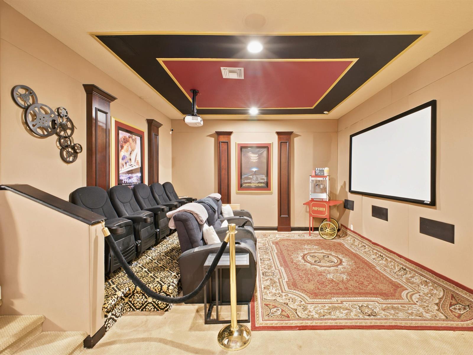 A home theater features tiered seating, a projector, a screen, and a popcorn machine — 7209 Serrano Terrace, Delray Beach FL 33446, DELRAY BEACH, FL