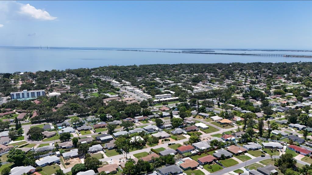 An aerial view shows a residential neighborhood situated along a large body of water — 1050 62ND AVE SOUTH UNIT E-4, ST PETERSBURG, FL