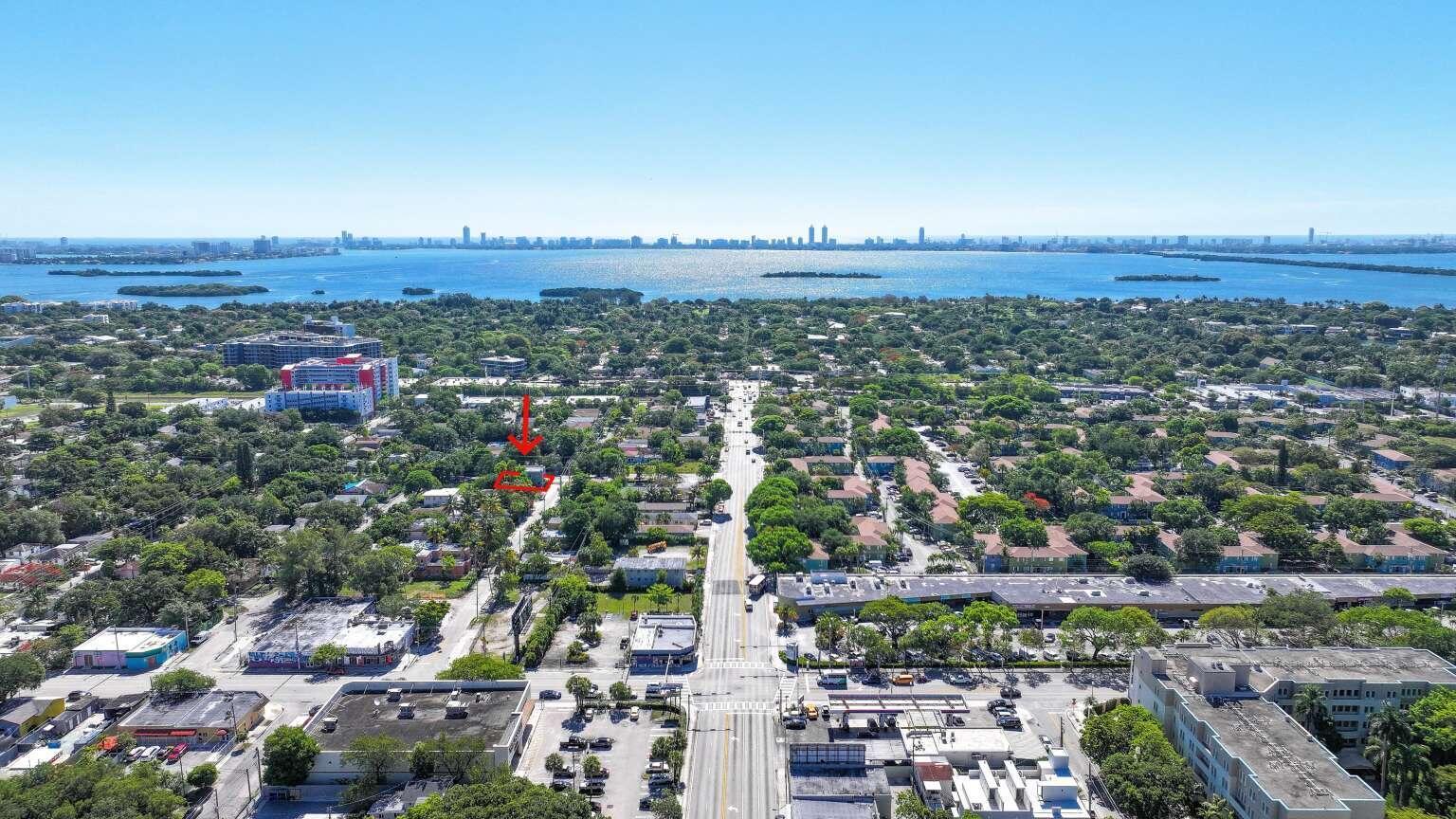 An aerial view shows a residential property highlighted by a red arrow in a neighborhood — 295 NE 55th Street, Miami FL 33137, MIAMI, FL