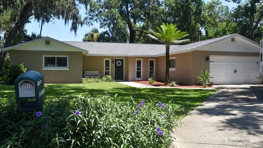 A single-story house with a tan exterior, gray roof, and a white garage door — 105 KENT COURT, PORT ORANGE, FL