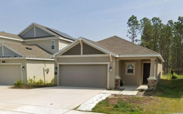 A single-story house with a beige stucco exterior, a two-car garage, and a covered entryway — 1122 Cabot Cliffs Dr, Daytona FL 32124, DAYTONA, FL