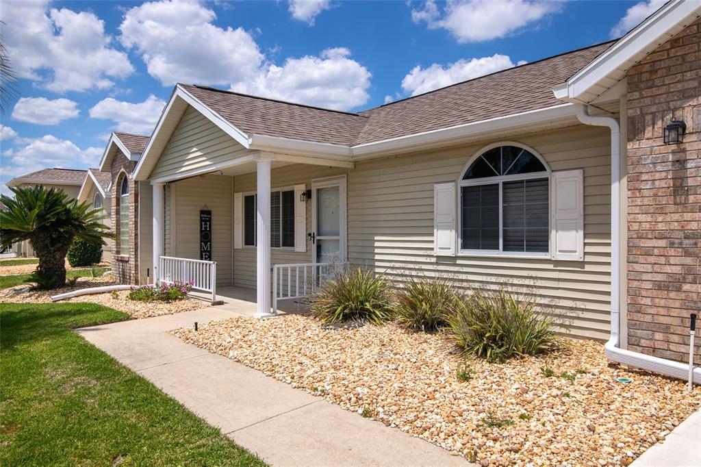 The exterior of a single-story house features light-colored siding, a covered porch, and rock landscaping — 5143 NW 18TH STREET, OCALA, FL