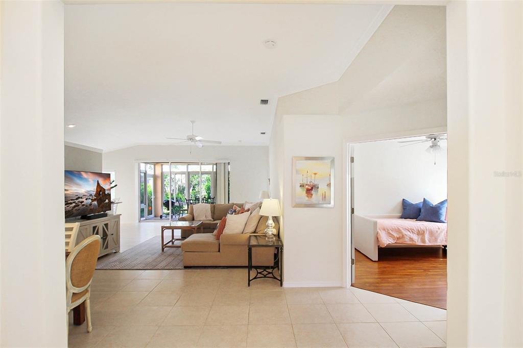 A view from a tiled entryway into a living room and an adjacent bedroom — 163 BRAEMAR AVENUE, VENICE, FL