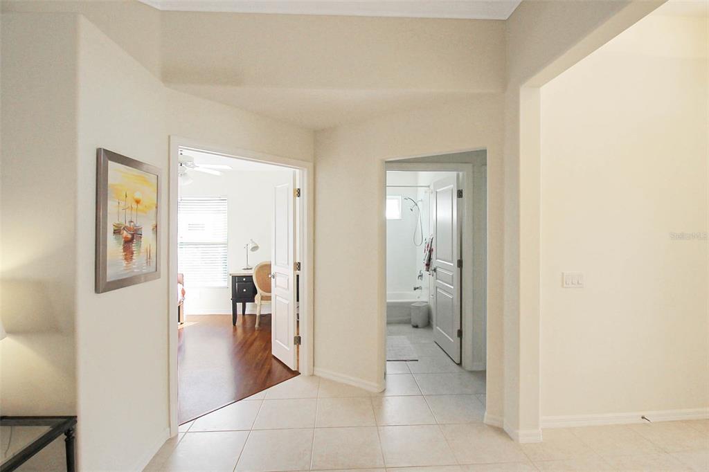 A tiled hallway leads to a bedroom on the left and a bathroom on the right — 163 BRAEMAR AVENUE, VENICE, FL