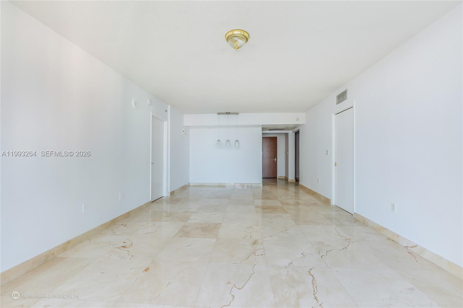 An empty room features white walls, a beige tiled floor, and a central ceiling light — 31 SE 5th St # 2708, Miami FL 33131, MIAMI, FL