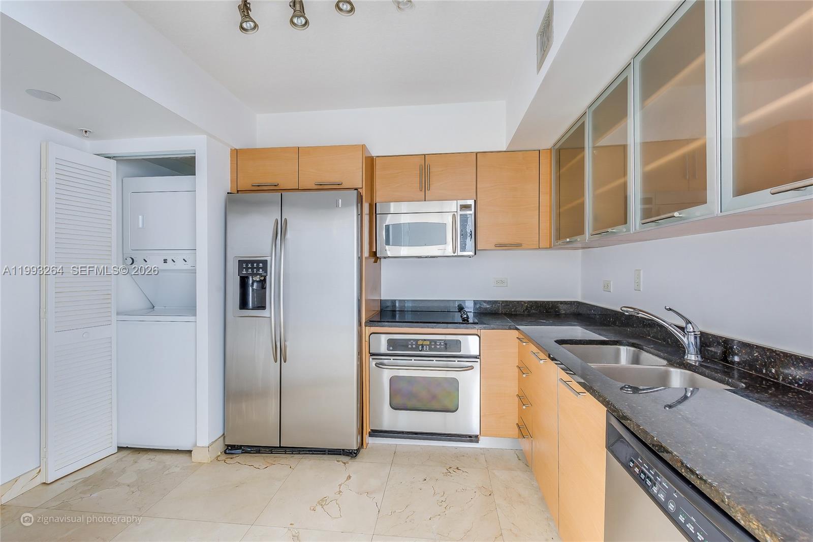 A kitchen features stainless steel appliances, light wood cabinets, and dark granite countertops — 31 SE 5th St # 2708, Miami FL 33131, MIAMI, FL
