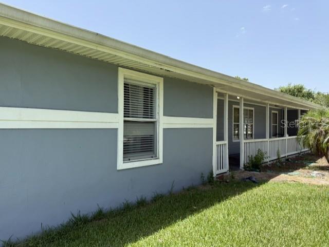The exterior of a gray house features a long covered porch and white trim — 1292 VALLEYBROOK ROAD SE, PALM BAY, FL