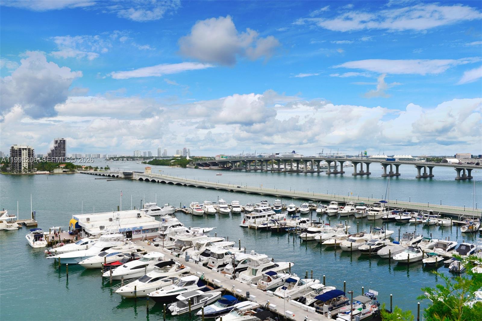 A high-angle view shows a marina filled with boats near a bridge and city skyline — 1717 N Bayshore Dr # 2254, Miami FL 33132, MIAMI, FL