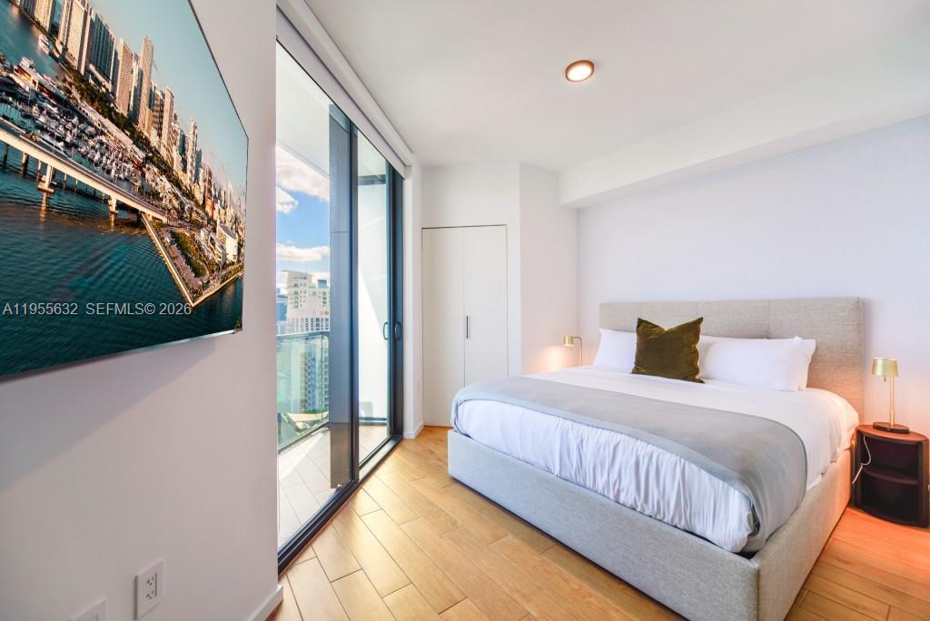 A modern bedroom features a king bed, hardwood floors, and a balcony with city views — 398 NE 5th St # 2314, Miami FL 33132, MIAMI, FL