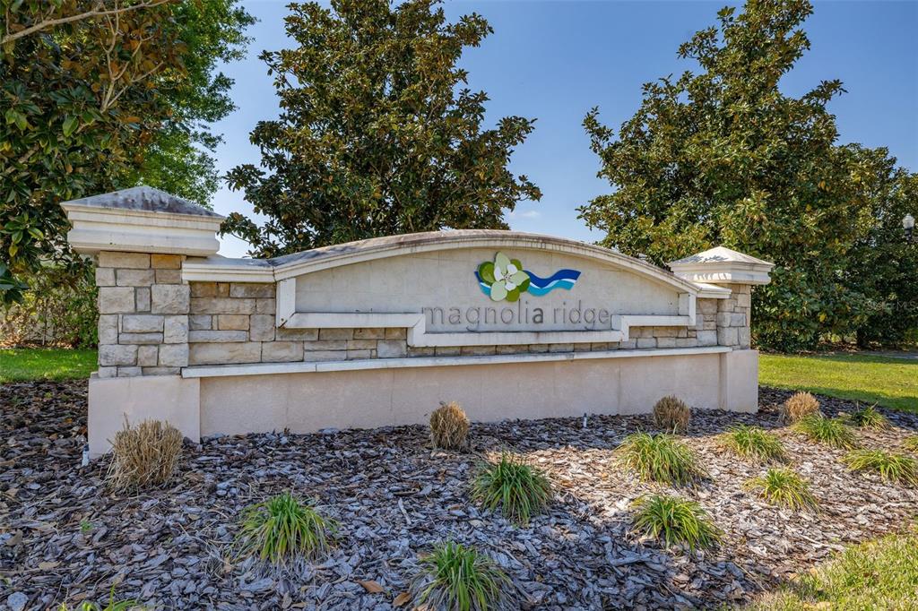 A stone monument sign for Magnolia Ridge stands in a landscaped bed with mulch — 1325 CYPRESS RIDGE LOOP, LAKE ALFRED, FL