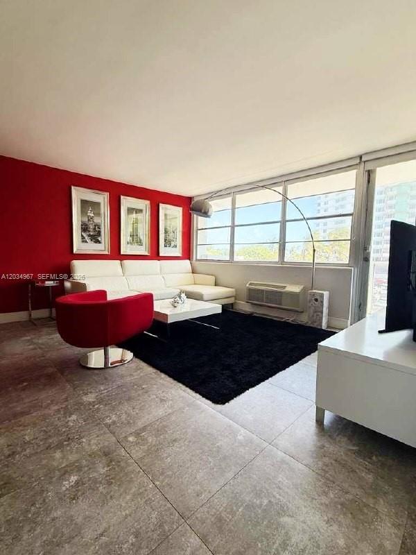 A living room features a white sectional sofa, a red armchair, and a black rug — MIAMI BEACH, FL