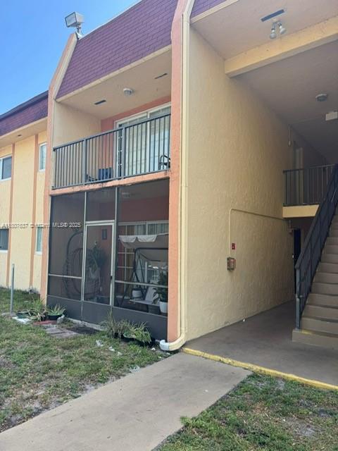 A two-story apartment building exterior features a screened-in patio, a balcony, and an outdoor staircase — 2970 NW 55th Ave # 2C, Lauderhill FL 33313, LAUDERHILL, FL