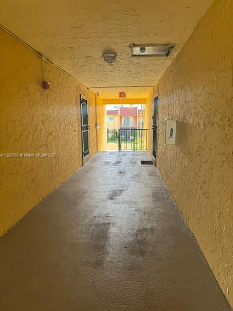 A covered outdoor walkway with yellow textured walls leads toward an exterior building view — 2970 NW 55th Ave # 2C, Lauderhill FL 33313, LAUDERHILL, FL