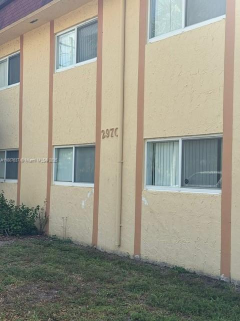 An exterior view of a two-story apartment building with beige stucco walls and windows — 2970 NW 55th Ave # 2C, Lauderhill FL 33313, LAUDERHILL, FL